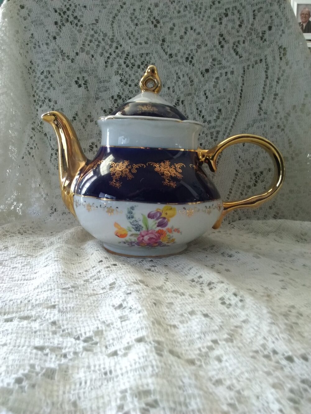 A White Alpine Cuisine Fine Porcelain Teapot. Cobalt Band Has Gold Filigree, Spout & Finial. Flowers Decorate The Bottom. Cs 229